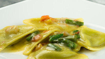 Ravioli di pesce con asparagi e gamberetti, piatto in primo piano