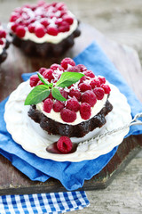 Sweet cakes with raspberries on wooden table background