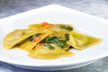 Ravioli di pesce con asparagi e gamberetti, piatto in primo piano