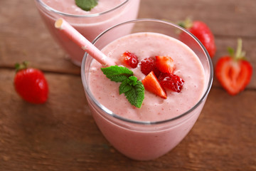 Fresh strawberry yogurt with berries around on wooden background