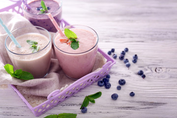 Obraz na płótnie Canvas Tasty strawberry, blueberry and milk yogurt on server against light wooden background