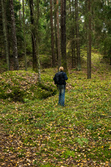Man with backpack hiking in fall forest