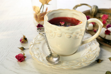 Tea set and tea rose flowers on table closeup