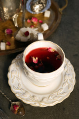 Cup of rose tea with sugar on wooden table
