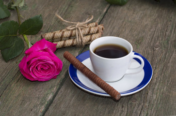 cup of coffee, one rose, linking of cookies on a wooden table, a