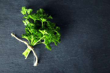 Obraz na płótnie Canvas Fresh parsley on dark grey background