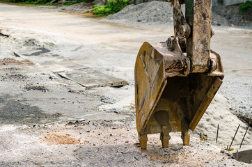 Fototapeta na wymiar Excavator scoop on the ground at construction work,road and water pipe