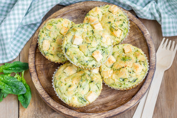 Snack muffins with spinach and feta cheese on a wooden plate