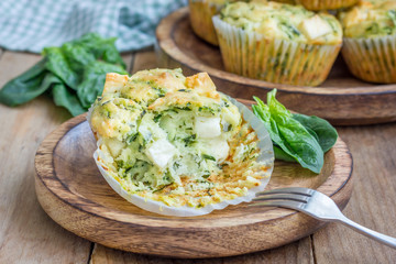 Snack muffins with spinach and feta cheese on a wooden plate