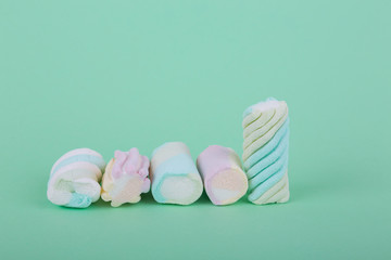  marshmallow candies vertically and horizontally, side view close-up on a turquoise background.