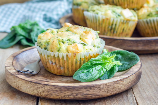Snack muffins with spinach and feta cheese on a wooden plate