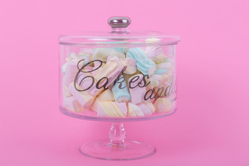 marshmallow candies of different colors in the glass on the background of pink. top view. entertainment for children in celebration.