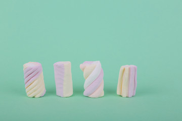 marshmallow candies in different colors on the background of turquoise. top view. entertainment for children in celebration.