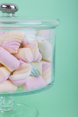 marshmallow candies of different colors in the glass on the background of turquoise. top view. entertainment for children in celebration.