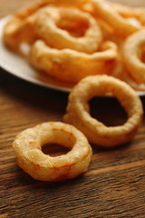 Chips rings on plate on wooden background