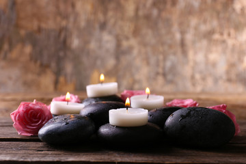 Tenderness relaxing composition with pebbles, roses and candles on wooden background