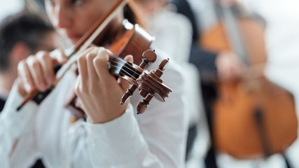 Talented violinist playing with orchestra © stokkete
