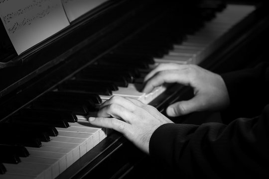 Young man playing on piano, close up