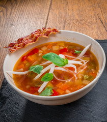 Vegetable soup served with crisp bacon