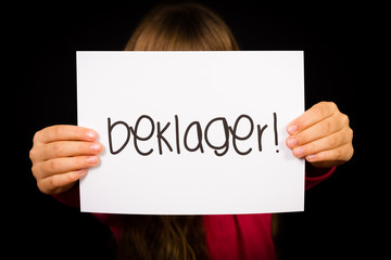 Child holding sign with Norwegian word Beklager - Sorry