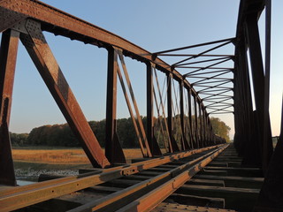 Old, closed railway bridge covered with rust