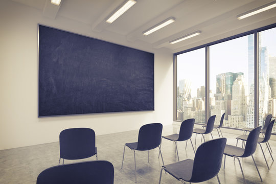 A classroom or presentation room in a modern university or fancy office. Black chairs, a black chalkboard on the wall and panoramic windows with New York view. 3D rendering. Toned image.