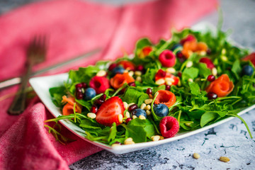 Healthy salad with arugula,spinach,smoked salmon and berries