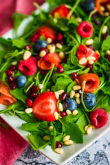 Healthy salad with arugula,spinach,smoked salmon and berries