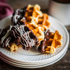 Belgian waffles with chocolate on rustic wooden background