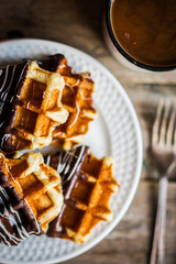 Belgian waffles with chocolate on rustic wooden background