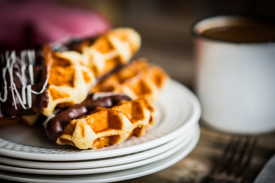 Belgian waffles with chocolate on rustic wooden background