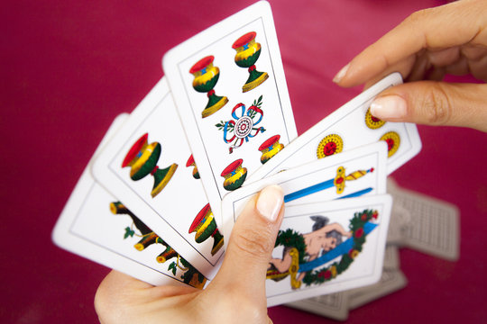 donna che gioca a briscola con carte piacentine
