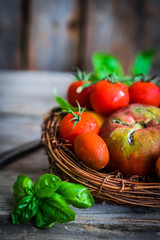 Fototapeta na wymiar Multicolored tomatoes on rustic wooden background