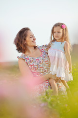 Happy mother with her kid in roses 