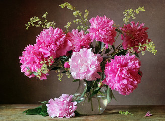 Bouquet of pink peonies in a transparent jug.