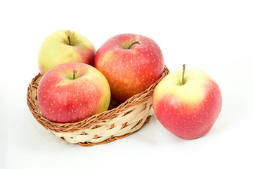Красно-зеленые яблоки в корзинке на белом фоне