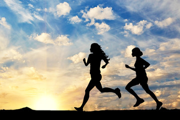 Fototapeta na wymiar Silhouette of two girls running competition