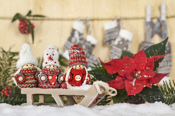 Weihnachtliche Wichtelmännchen auf einem Schlitten im Schnee