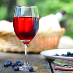 Red wine with scattered berries on a wooden table