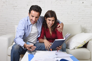 attractive couple accounting debt at home couch happy in financial success and wealth