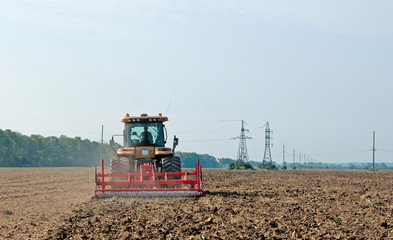 Fototapeta premium tractor processes field