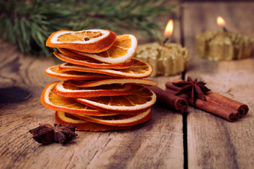 sliced dried orange, cinnamon sticks, anise stars and candle with pine brunch