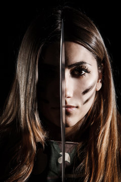 Woman holding a knife at the middle of her face