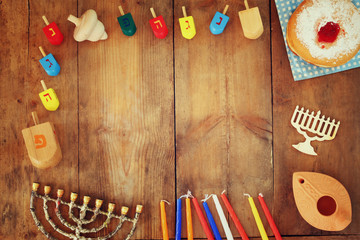 top view image of jewish holiday Hanukkah with menorah (traditional Candelabra), donuts and wooden dreidels (spinning top). retro filtered image
