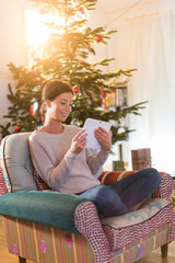 Christmas morning, beautiful young woman sitting in an armchair
