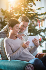 On Christmas morning, beautiful couple sitting in the living roo