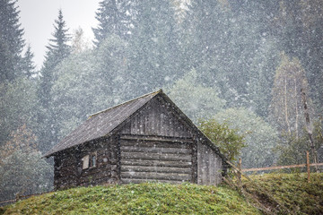 Old country house during heavy snowfall in Carpathians mountains
