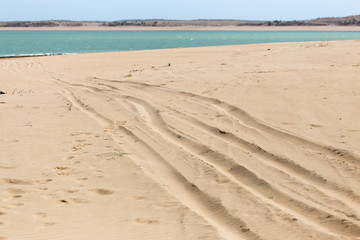 Fototapeta na wymiar road in the sand on the lake