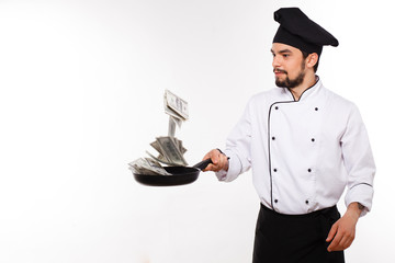 happy male in cook uniform holding money on white background