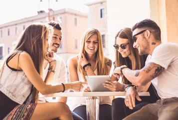 Group of friends watching tablet in a bar